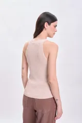 Musculosa beige de punto con brillo sutil.