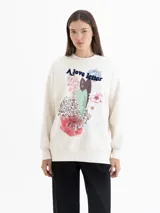 Buzo oversize de cuello redondo y manga larga, color crema. Presenta una estampa frontal con motivos florales, corazones y la frase 'A love letter to winter flowers'.