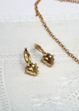 Aros de tipo argolla pequeña con dije de corazón irregular con detalles en relieve, con baño de oro de 24K.