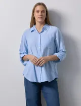 Camisa de lino marca Dash, color celeste, con cuello camisero, cierre frontal de botones, bolsillo aplicado en el pecho y mangas largas regulables.
