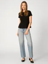 Remera blanca de manga corta con cuello redondo, confeccionada en una mezcla de modal, poliéster y elastano. Presenta un diseño con alforzas verticales en el frente que aportan estructura y una silueta relajada.