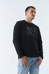 Remera de manga larga negra con estampado rectangular en el frente con letras grises. Corte recto y cuello redondo.