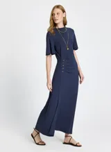 Vestido largo azul marino de punto ligero, con escote redondo, mangas cortas, abertura lateral y detalle de botones dorados en el lateral.