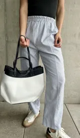 Pantalón de pijama rayado en tonos gris y blanco, de corte recto y relajado, con cintura elástica.