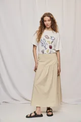 Falda midi de denim color beige, con diseño de volados y caída fluida.