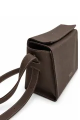 Cartera tipo bandolera de Daniel Cassin, color negro con textura granulada, costuras blancas a contratono y correa ajustable. Presenta el nombre de la marca impreso en plateado en la parte frontal.