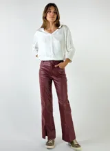 Pantalón de cuero marrón, de corte recto con abertura en el ruedo.