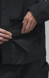 Chaqueta técnica liviana de microfibra con acabado mate, diseño con mangas desmontables que permiten convertirla en chaleco. Cuenta con cuello tipo camisa, cierre frontal oculto, cuatro bolsillos frontales de gran tamaño y puños elásticos. Incluye logo bordado en relieve en el pecho.