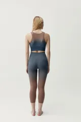 Calza deportiva corta de diseño seamless, con efecto degradado que transiciona del gris azulado en la parte superior al marrón en las piernas.