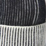 Gorro tipo beanie de punto, con diseño bicolor en negro y blanco, presentando un patrón de rayas verticales en el borde doblado.