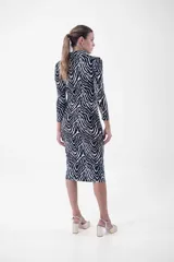 Vestido midi de corte ajustado, con estampado animal print tipo cebra en blanco y negro, cuello camisero, escote en V y cierre frontal con botones dorados.