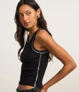 Musculosa de rib en color negro, con diseño ajustado al cuerpo, cuello redondo y frisos contrastantes blancos en el escote y las sisas.