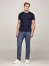 Remera azul marino de corte slim, confeccionada en tejido interlock de algodón elástico. Tiene cuello redondo y logo de Tommy Hilfiger bordado en el pecho.