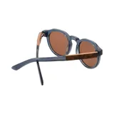 Lentes de sol Indie modelo Honey, con montura redonda de acetato azul y lentes marrones. Patillas de madera. Hechos a mano y sustentables.