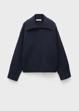 Buzo de lana de punto grueso en color azul marino, con cuello de solapa y diseño recto con aberturas laterales en el bajo.
