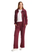 Pantalón tipo jogger de corte ancho y fluido, color bordó, con cintura elástica, bolsillos laterales y detalle de bordado floral calado en el ruedo.