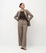 Pantalón de sastrería modelo wide leg con estampado de cuadros, confeccionado en tejido crepé. Presenta cintura alta estructurada con trabillas, bolsillos traseros y cierre discreto.