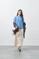 Sweater de tejido liviano con silueta relajada, hombros caídos y mangas largas con puños ajustados. Presenta cuello redondo y lazos ajustables en el bajo.