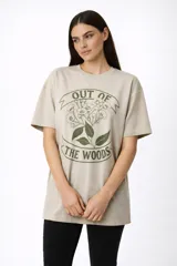 Remera de algodón de corte holgado, color beige con estampado botánico en color verde oliva y texto en el frente.
