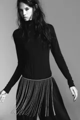 Cinturón metálico plateado con flecos de cadenas finas y brillantes. Cierre con mosquetón.