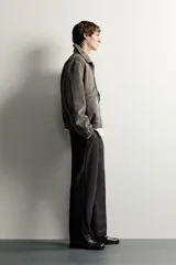 Cazadora de hombre regular fit confeccionada en tejido efecto ante, con acabado lavado, cuello solapa, manga larga, bolsillos de plastrón con solapa en la cadera, detalles elásticos en puños y cintura, y cierre frontal de cremallera.