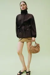 Bolso de hombro formato mini shopper confeccionado en piel de ante, con diseño fruncido, doble asa de mano y cierre mediante clip metálico.