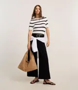 Blusa de punto ligero con diseño de rayas horizontales, cuello redondo y mangas cortas. Confeccionada en una mezcla de viscosa y poliamida, presenta un ajuste al cuerpo.