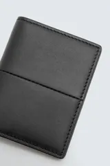 Tarjetero de piel color negro con costura central y cuatro ranuras para tarjetas.