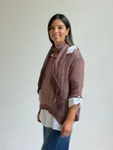 Sweater de punto color marrón chocolate con cuello redondo, mangas tres cuartos y diseño asimétrico. Incluye un pañuelo a juego con detalles de puntilla en los bordes.
