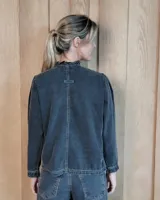 Camisa de manga larga con estampado de rayas verticales en tonos crudo y beige. Presenta cuello alto con volados, cierre frontal con botones dobles y puños con volados.