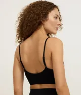 Soutien tipo top de color negro, confeccionado en tejido seamless texturizado con tirantes finos ajustables. Cuenta con copas desmontables y diseño sin costuras.