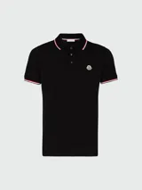 Polo de piqué de algodón blanco de manga corta, con cuello y puños con ribetes tricolor (rojo, blanco y azul marino). Presenta un pequeño logo bordado en el pecho.