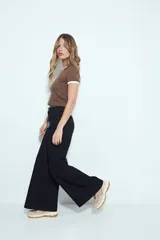 Pantalón de pierna amplia color beige, con silueta relajada y calce cómodo, confeccionado en denim con leve elasticidad. Presenta costuras a contraste.