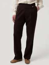 Pantalón de vestir color marrón oscuro, de corte recto y tiro alto. Confeccionado en una mezcla de lana y poliéster reciclado, presenta una pretina limpia con un botón lateral decorativo y cierre invisible lateral.