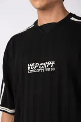 Remera de tejido de punto con textura calada, color crema con rayas verticales sutiles. Presenta cuello en V, mangas cortas con franjas laterales en color marrón oscuro y logo bordado en el centro del pecho.