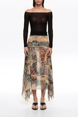 Falda midi de corte irregular con vuelo, confeccionada en viscosa. Presenta cierre lateral con cremallera invisible y tiras desflecadas que aportan movimiento y textura, con diseño estampado tipo patchwork.