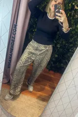 Pantalón de corte recto con estampado animal print en tonos beige y gris. Presenta cintura elástica y diseño holgado.