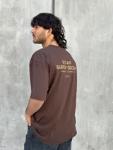 Remera marrón de corte oversize con estampado pequeño en el pecho.