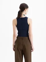 Top negro de tejido frío, ajustado al cuerpo y largo por debajo de la cintura.