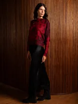 Buzo de punto de manga larga con cuello redondo, confeccionado en un tejido suave de textura peluda. Presenta un diseño estampado con motivos florales y ornamentales en color negro sobre una base de color rojo intenso.