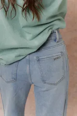 Pantalón de jean color arena con silueta wide leg, tiro medio-alto y costuras verticales delanteras que estilizan la figura. Cuenta con bolsillos funcionales y cierre frontal con doble botón.