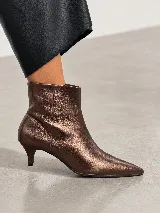 Bota corta de cuero con punta fina y taco fino de 5 cm, diseño minimalista y elegante.