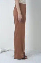 Pantalón marrón de corte recto con pinzas en la cintura.