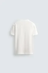 Camiseta blanca de manga corta con cuello redondo y tapeta de botones frontal (cuello panadero o henley).