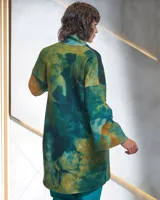Tapado de lana merino afieltrada con teñido artesanal tie dye en tonos verdes y ocres. Tiene cuello alto, cierre cruzado asimétrico con broches, bolsillos laterales y corte holgado.