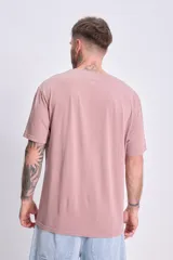 Remera manga corta oversize color rosa con estampa frontal con la leyenda "Art Studios" en gris.