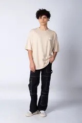 Remera de corte oversize color blanco, con cuello redondo y mangas cortas. Presenta un pequeño logo estampado en el pecho y un diseño gráfico grande en la espalda que incluye la frase 'Good Children' e ilustraciones de un ángel y llamas.