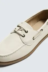 Zapato náutico de piel con diseño clásico, horma redonda y suela de goma a contraste.