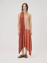 Vestido midi de lino con diseño geométrico en tonos tostado, marrón y terracota. Presenta cuello redondo, diseño sin mangas, corte clásico y dobladillo asimétrico con picos.