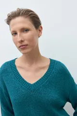 Sweater de tejido de punto color verde petróleo, con escote en V y mangas largas.